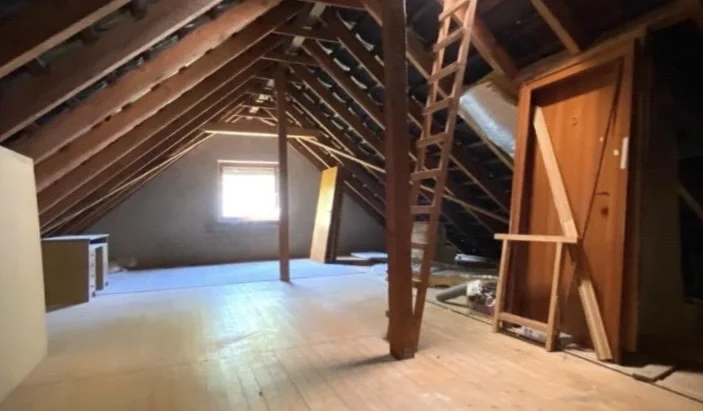 Unausgebauter Dachboden in Hamburg-Poppenbüttel mit offenem Dachstuhl, Holzdielen, Holzleiter und einer alten Holztür